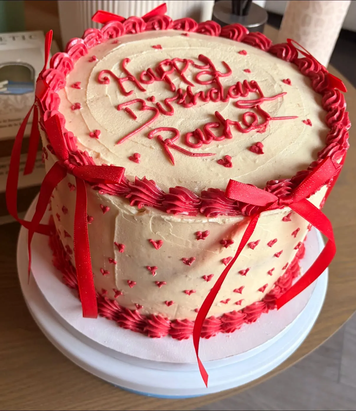 A custom birthday cake decorated with piped red hearts